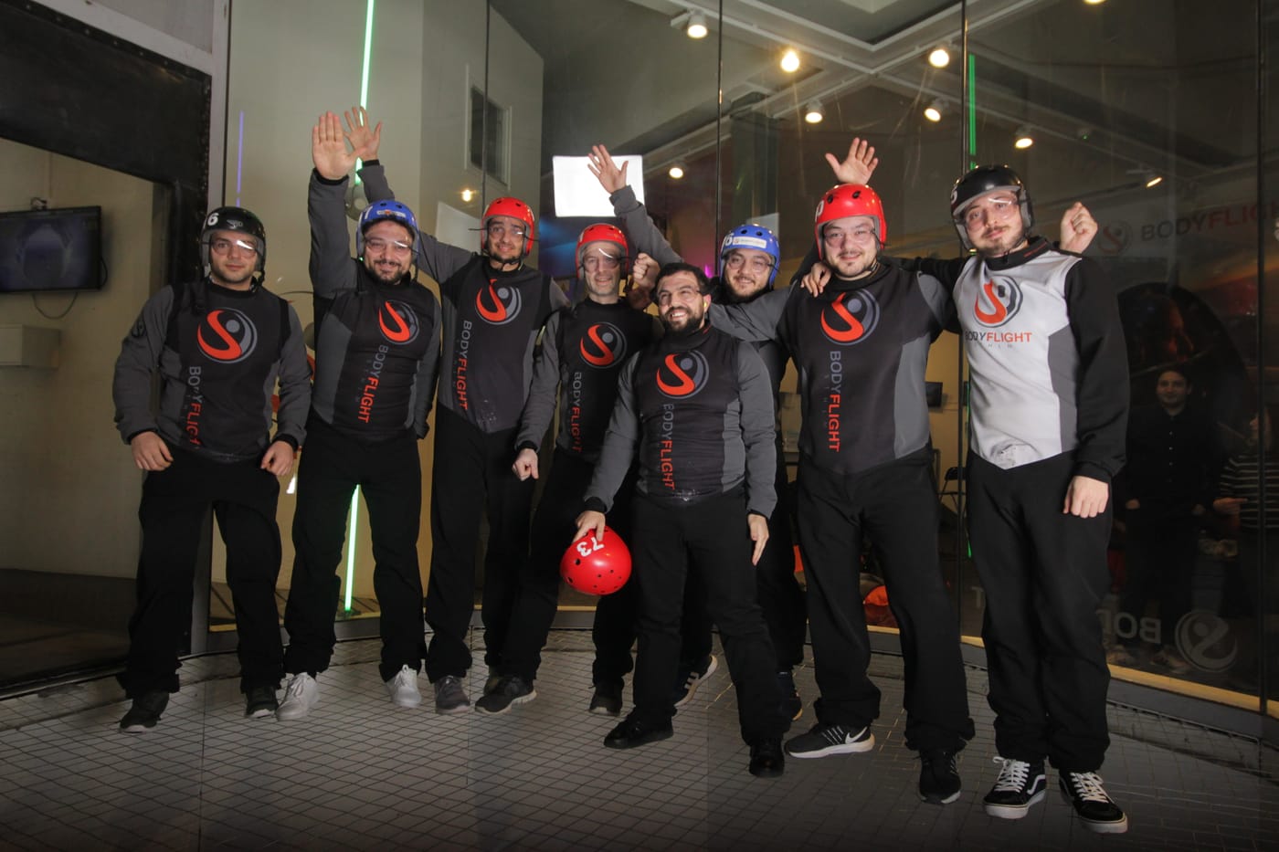 SwedQ team in matching flight suits celebrating at an indoor skydiving centre