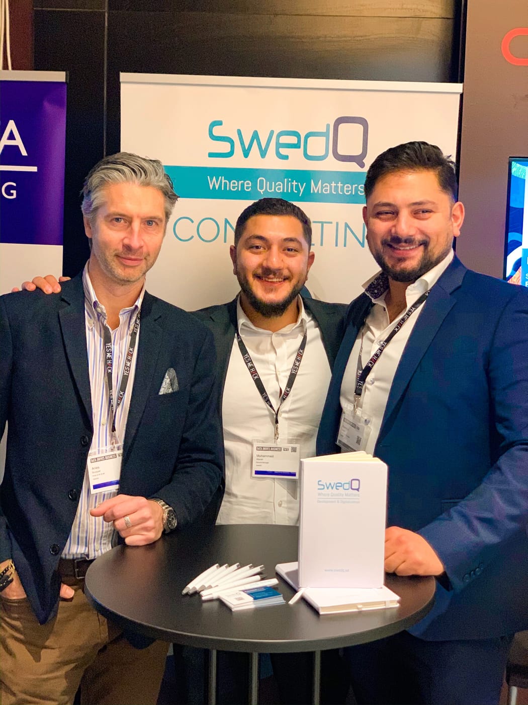 Three SwedQ colleagues at the company exhibition stand during an industry event